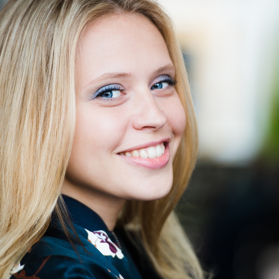 Woman smiling with perfect smile and white teeth in a park and looking at camera
