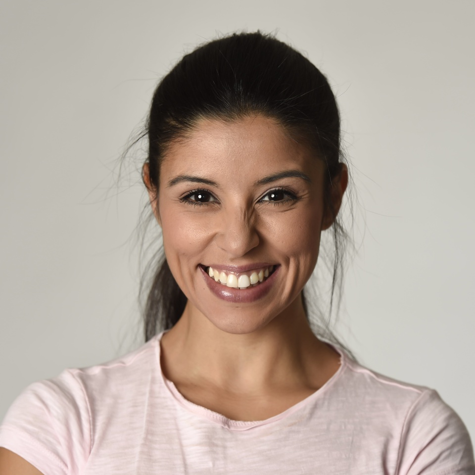 portrait of young beautiful and happy Latin woman with big toothy smile excited and cheerful in charming face expression isolated clear grey background in female happiness emotion
