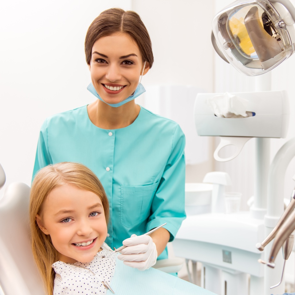 Little beautiful girl at the dentist looking at the camera and smiling