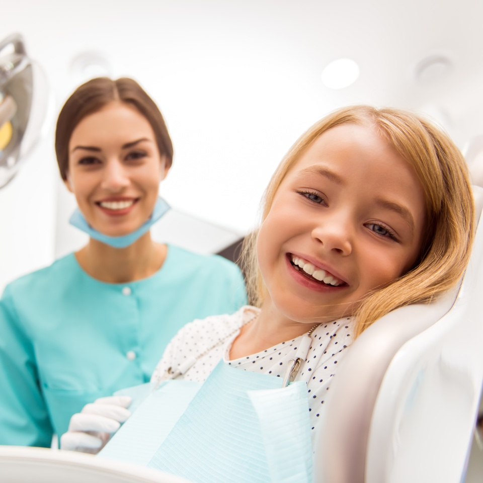 Little beautiful girl at the dentist looking at the camera and smiling