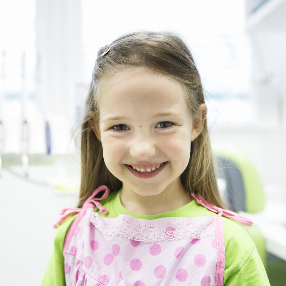 Relaxed little girl at dental office smiling and waiting for a checkup.