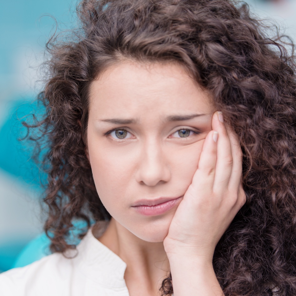 Portrait of a young woman suffering from toothache