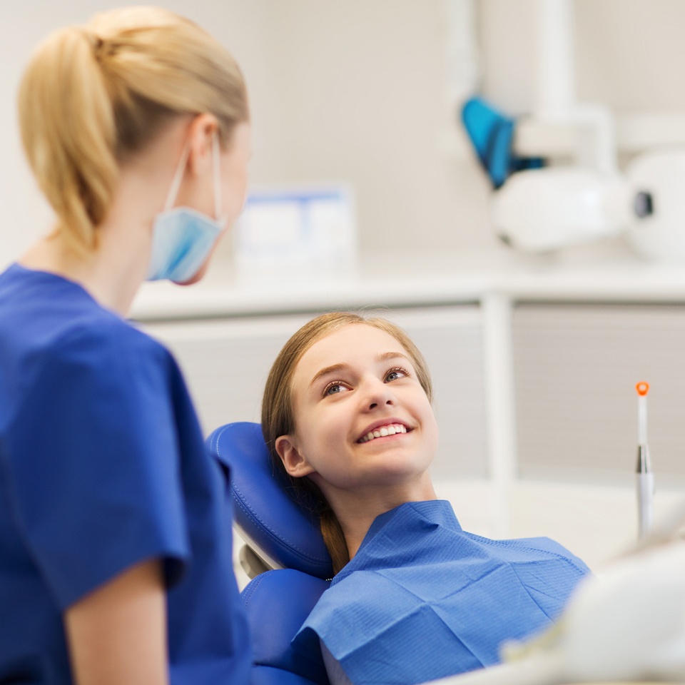 happy female dentist with patient girl at clinic