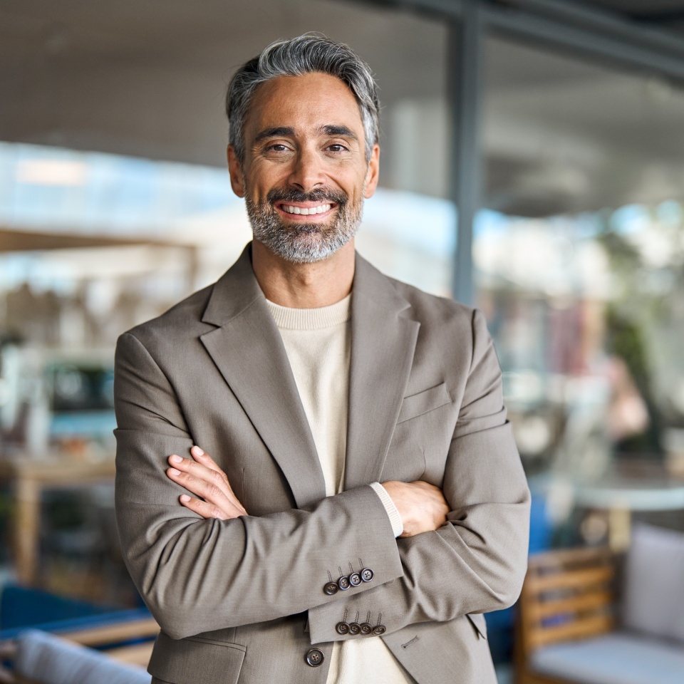 Happy middle aged business man entrepreneur looking at camera outdoors. Smiling confident mature businessman professional executive, successful lawyer wearing suit standing arms crossed, portrait.