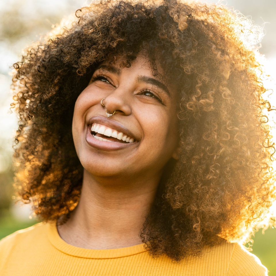 Happy young black woman smiling outside - Joyful beautiful girl laughing outdoors - Positive emotions, people portrait life style photo concept