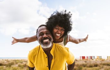 Beautiful mature black couple of lovers dating at the seaside - Married african middle-aged couple bonding and having fun outdoors, concepts about relationship, lifestyle and quality of life
