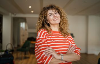 One woman caucasian female happy confident stand indoor at cafe with curly hair portrait smile real person copy space